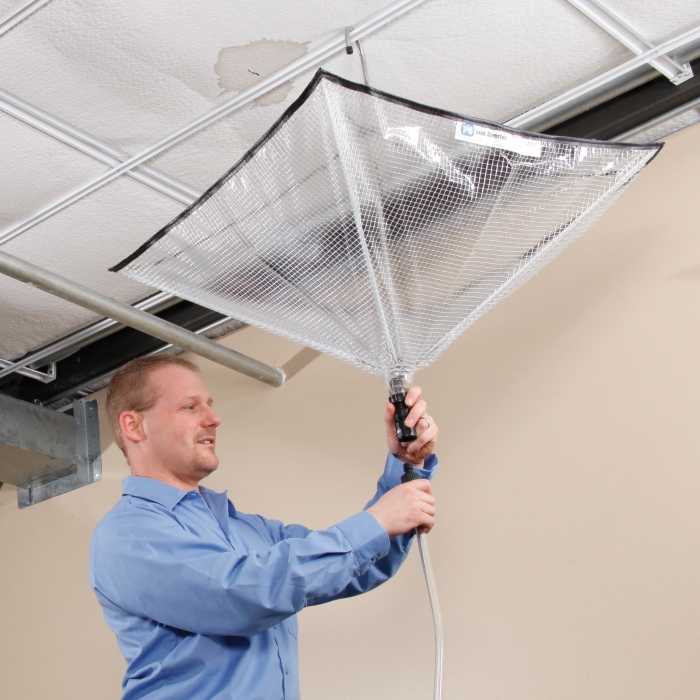 man hanging leak diverter tarp from ceiling